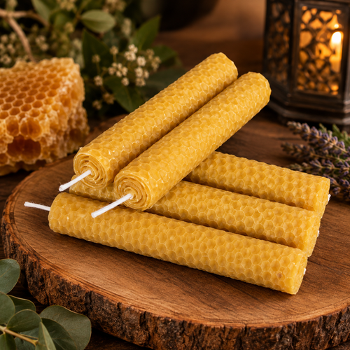 Velas artesanales de cera de abeja 100% natural enrolladas sobre superficie de madera