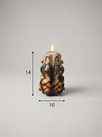 Vela escultural artesanal de relieve entrelazado con medidas de 14 cm de alto y 10 cm de ancho