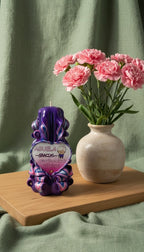 Vela artesanal para abuela con dedicatoria decorativa sobre mesa junto a flores